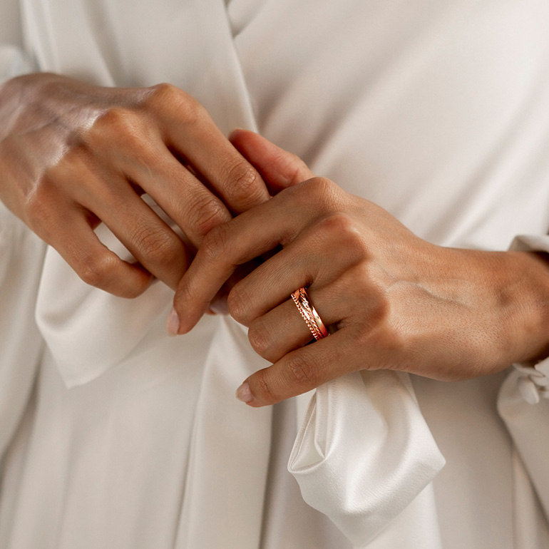 Hände einer Braut mit einem Ehering.