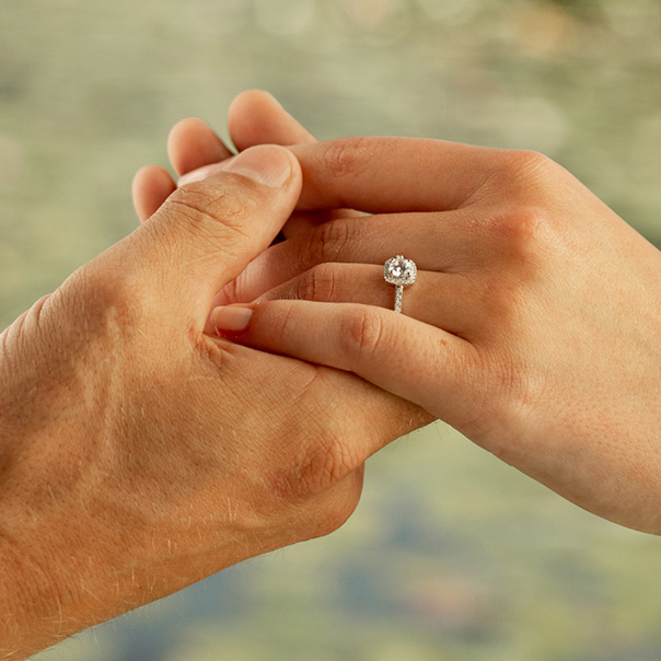 Ein Pärchen hält Hände, auf einem Finger ist ein Ring.